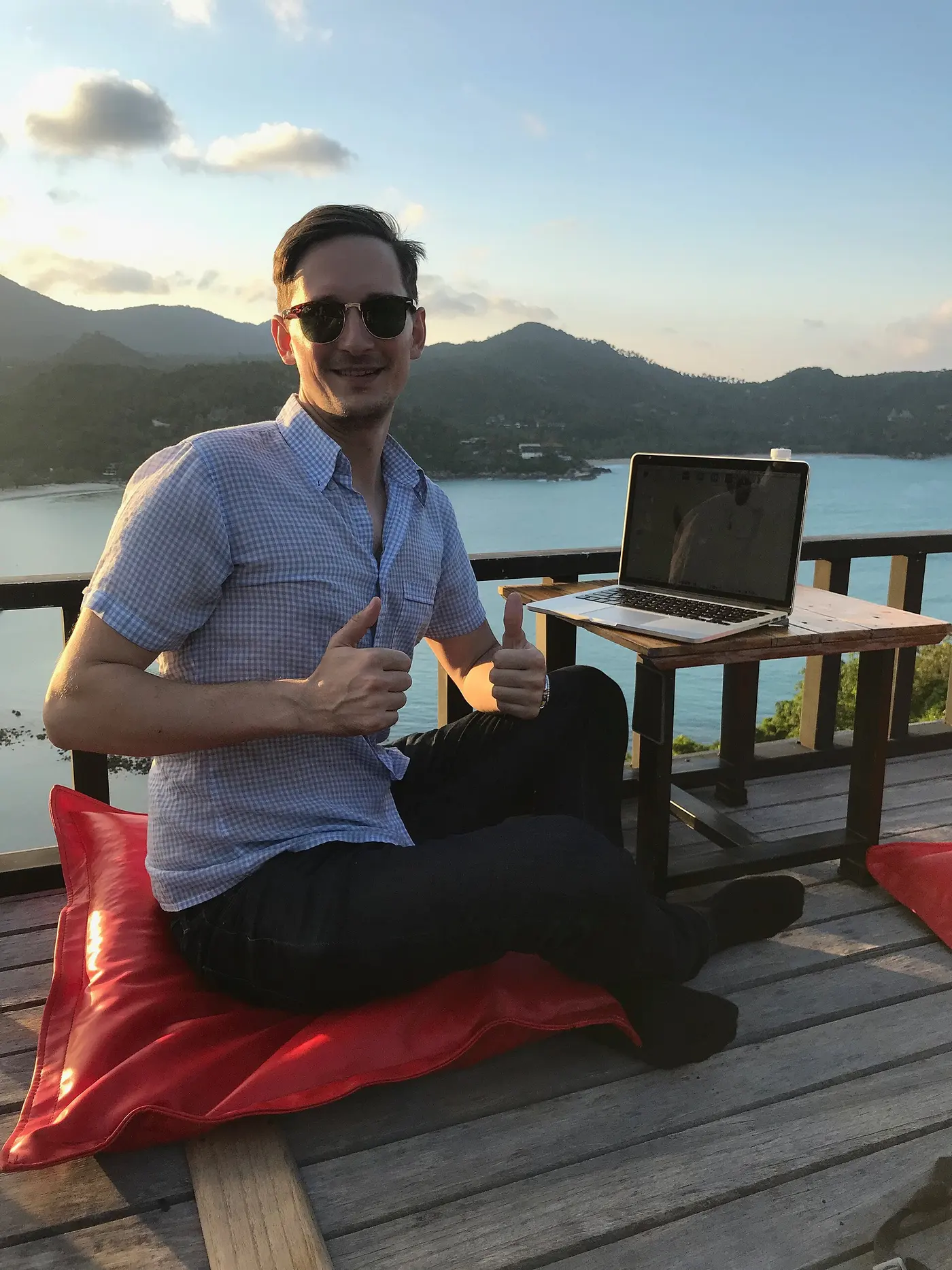 Một người làm việc với laptop ngoài trời, bên hồ